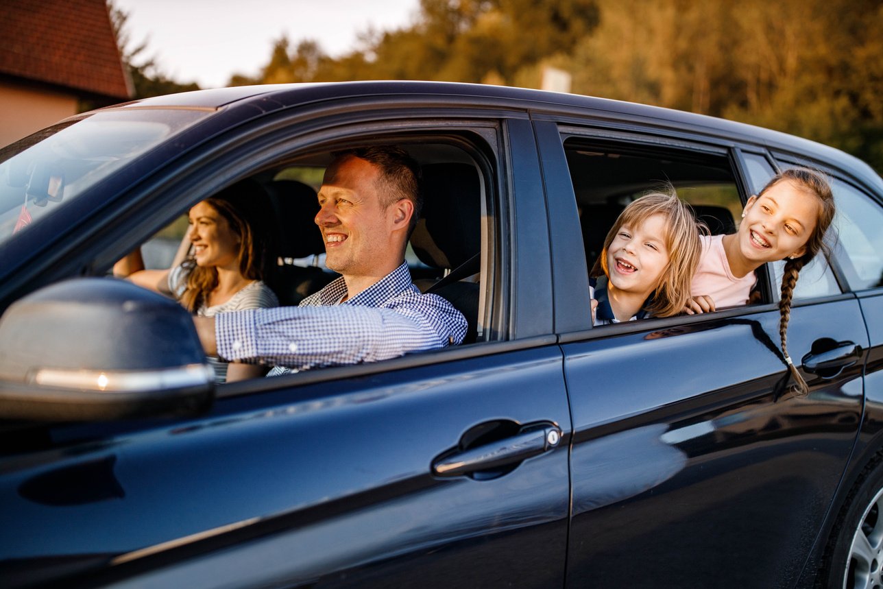 Young happy family traveling by car.